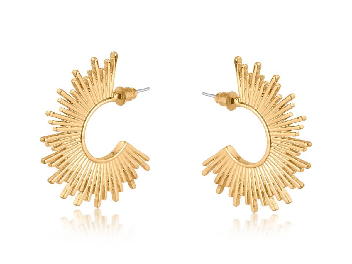 A pair of gold crescent-shaped hoop earrings with a textured sunburst or fan design radiating from the bottom curve, shown on a white background with a soft reflection.