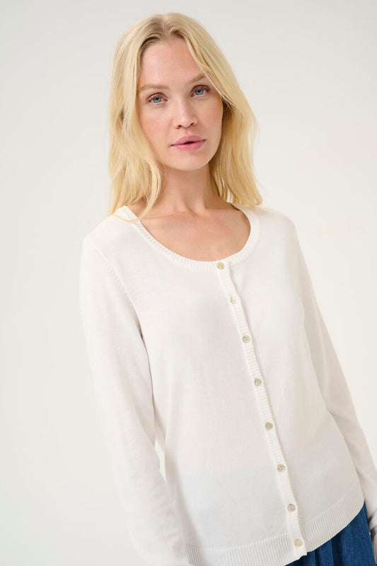 Woman wearing a white cardigan against a plain background