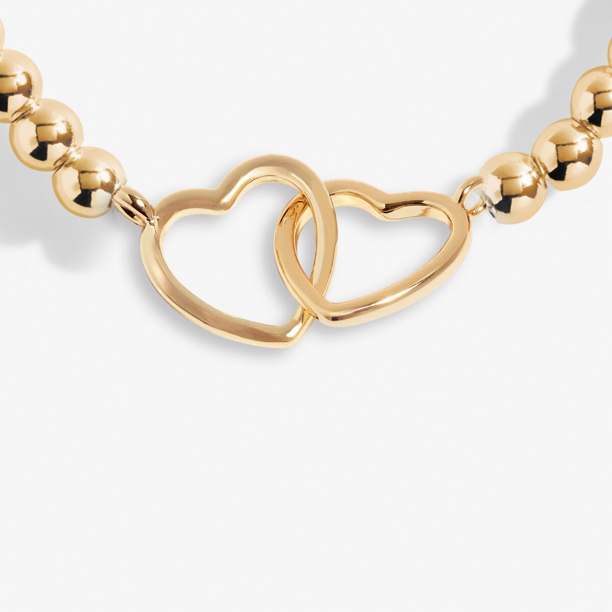 Gold bracelet with heart-shaped links on a light gray background