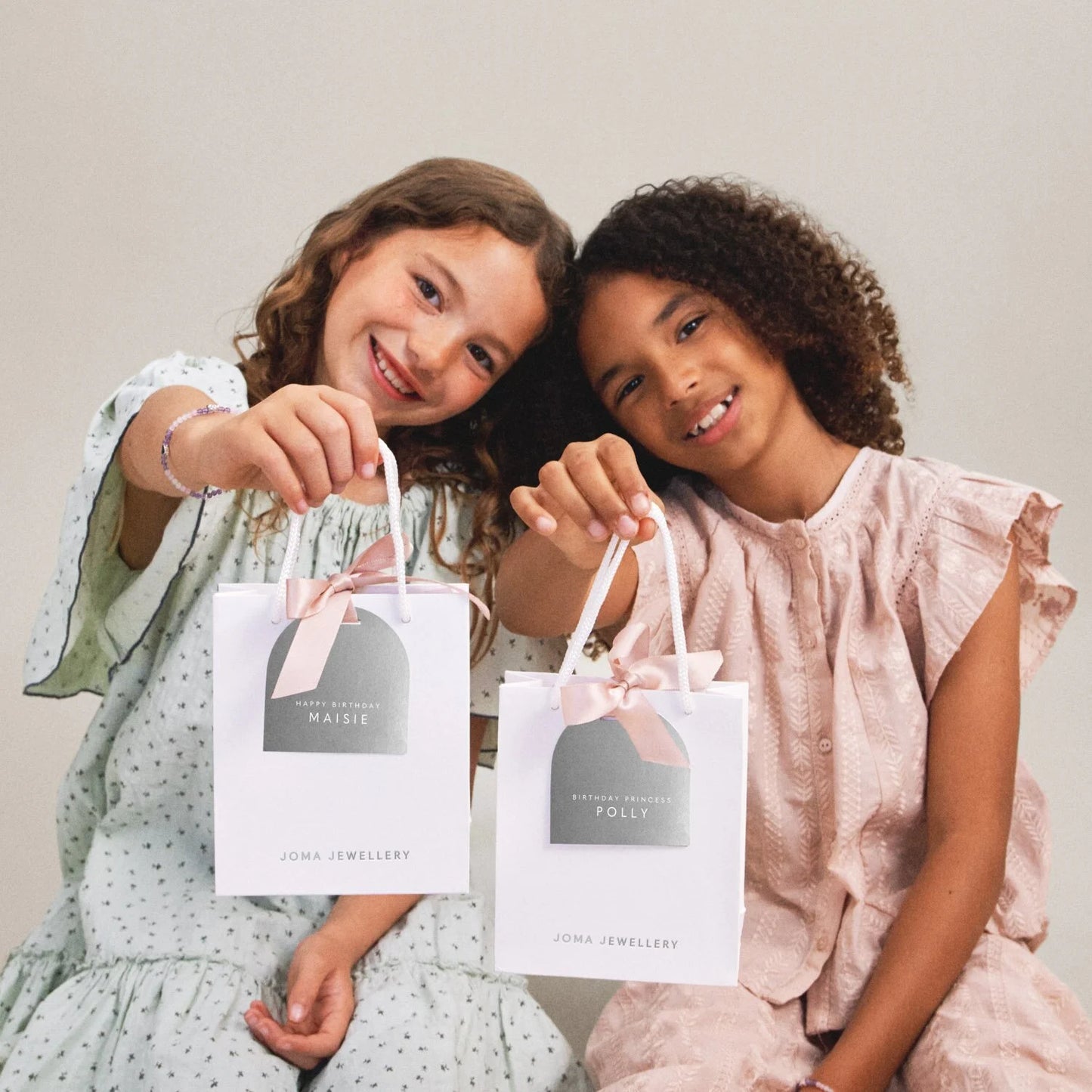 girls holding Joma gift bags