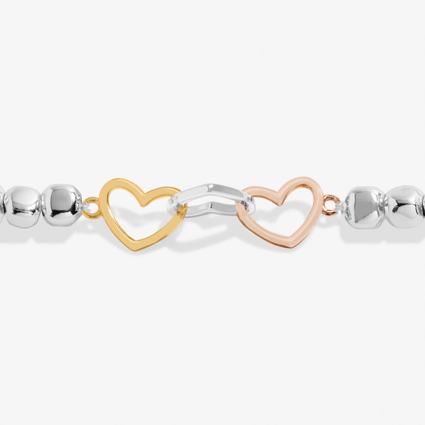 Bracelet with heart and infinity links in gold, silver, and rose gold on a white background