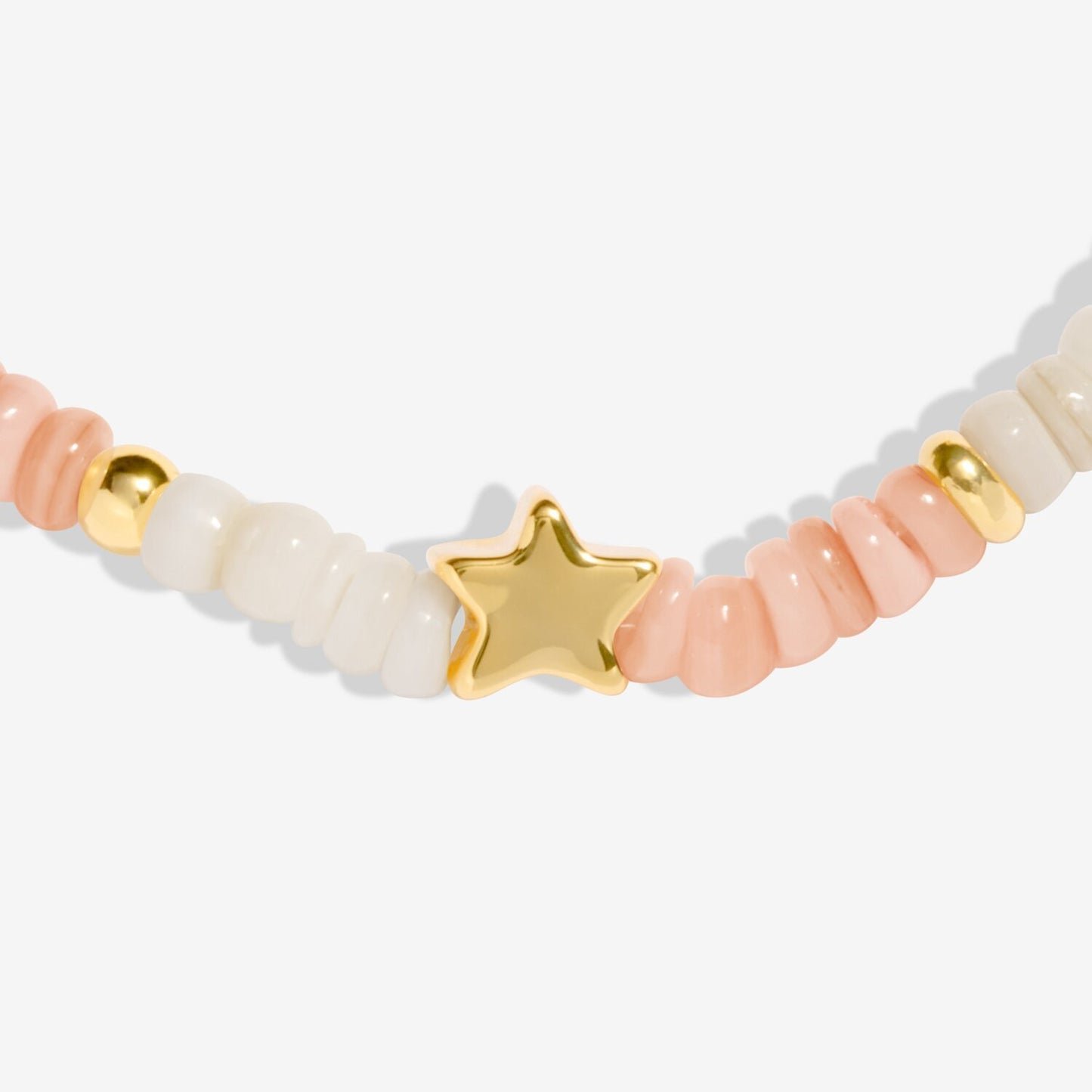 Bracelet with pink and beige beads and a gold star charm on a white background