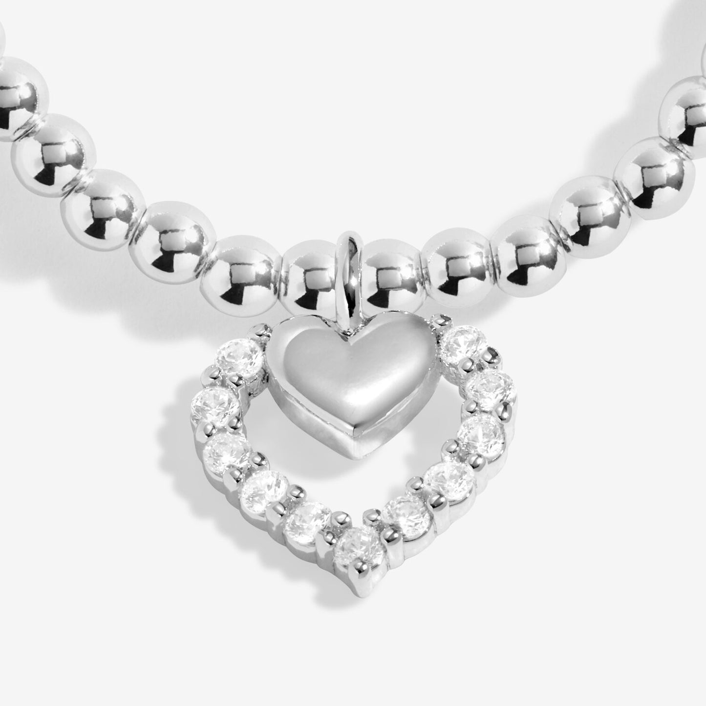 Silver heart-shaped bracelet with clear gemstones on a white background