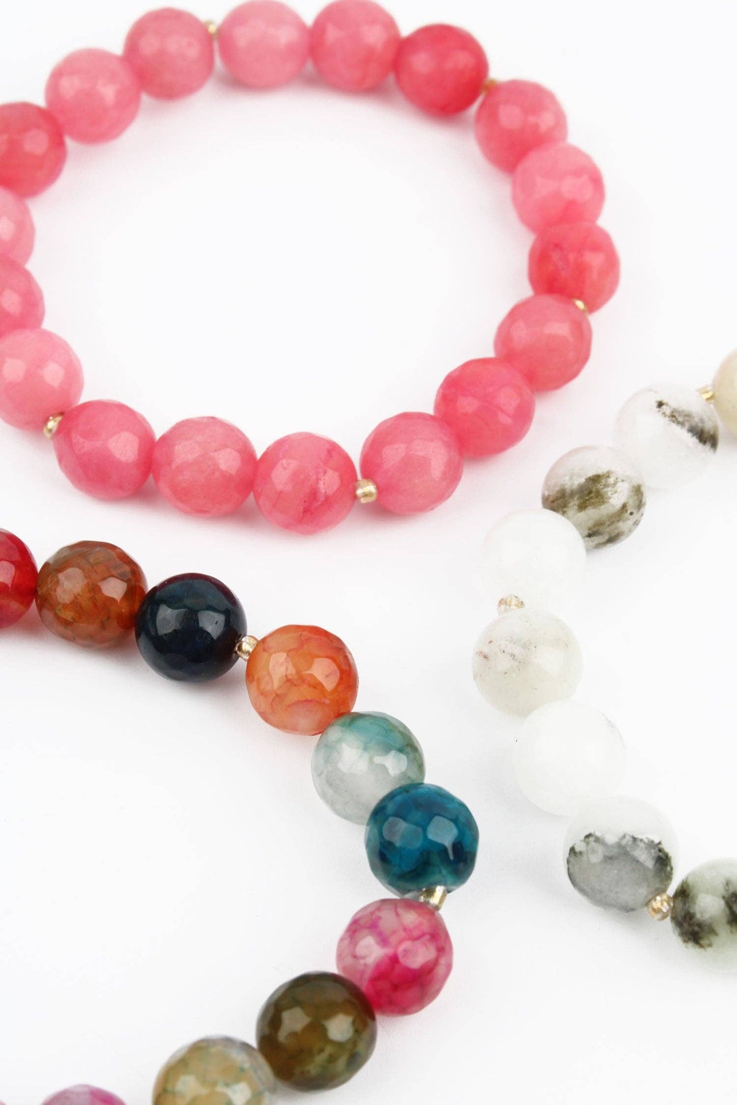 Two beaded bracelets with pink, red, and multicolored beads on a white background.