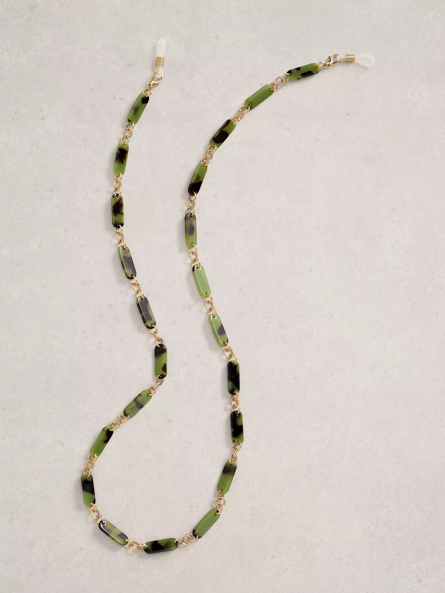 Necklace with green and black beads on a light gray background