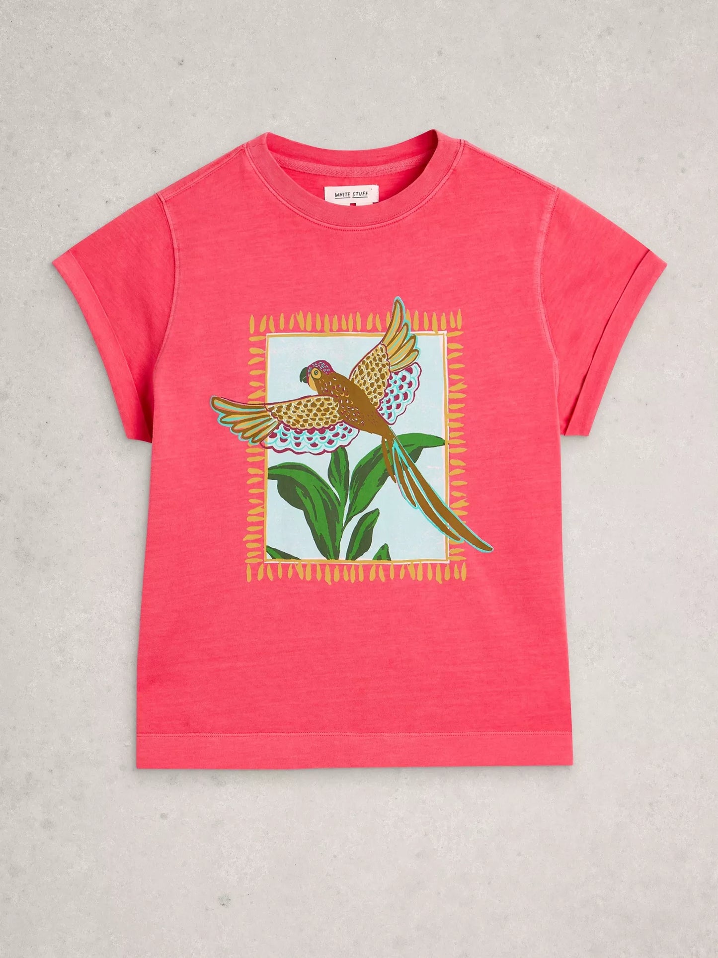 Red t-shirt with a bird and leaf graphic on a gray background