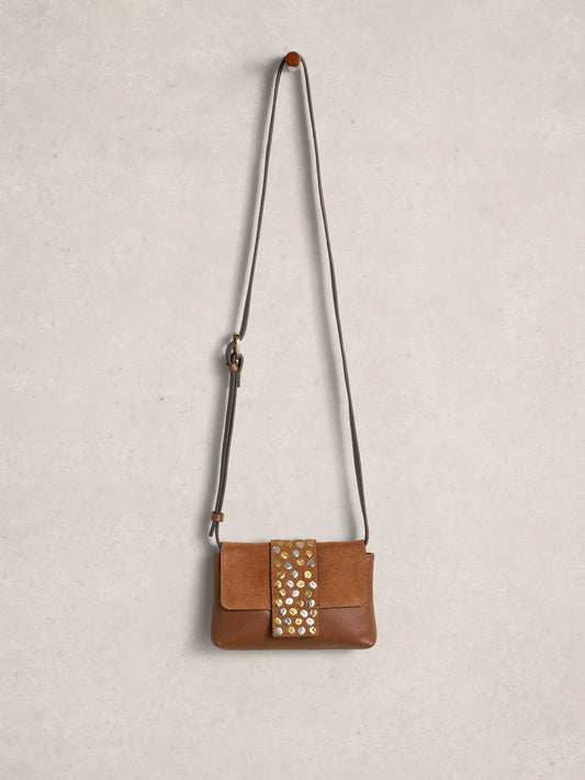 Brown leather handbag with studded detail on a light gray background