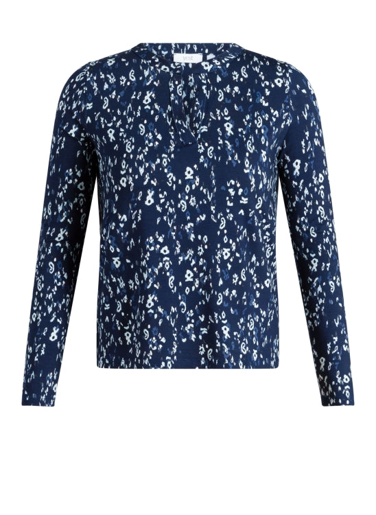 A long-sleeve V neck top featuring an all-over white floral and paisley print on a navy blue base, presented on a clean white background.