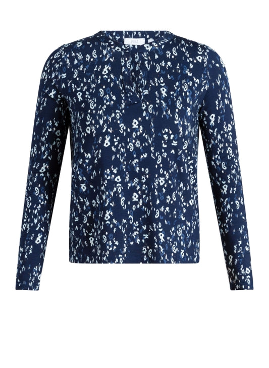 A long-sleeve V neck top featuring an all-over white floral and paisley print on a navy blue base, presented on a clean white background.