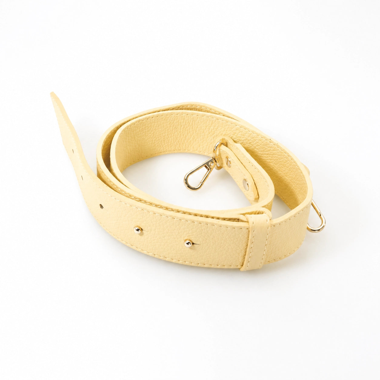 Yellow bag strap with gold hardware on a white background