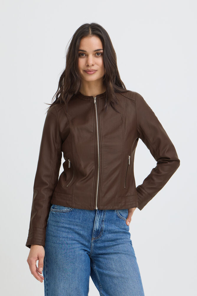 Woman wearing a brown leather jacket and blue jeans on a white background