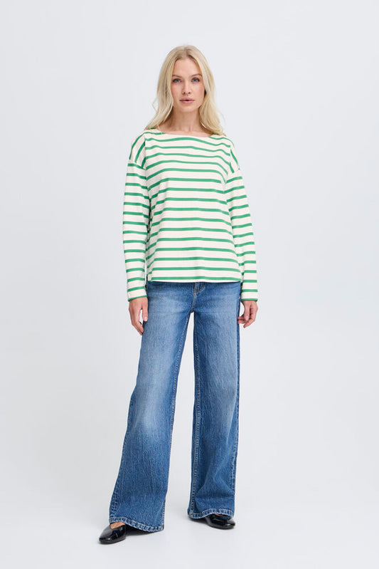 Woman wearing a green and white striped sweater and blue jeans on a white background