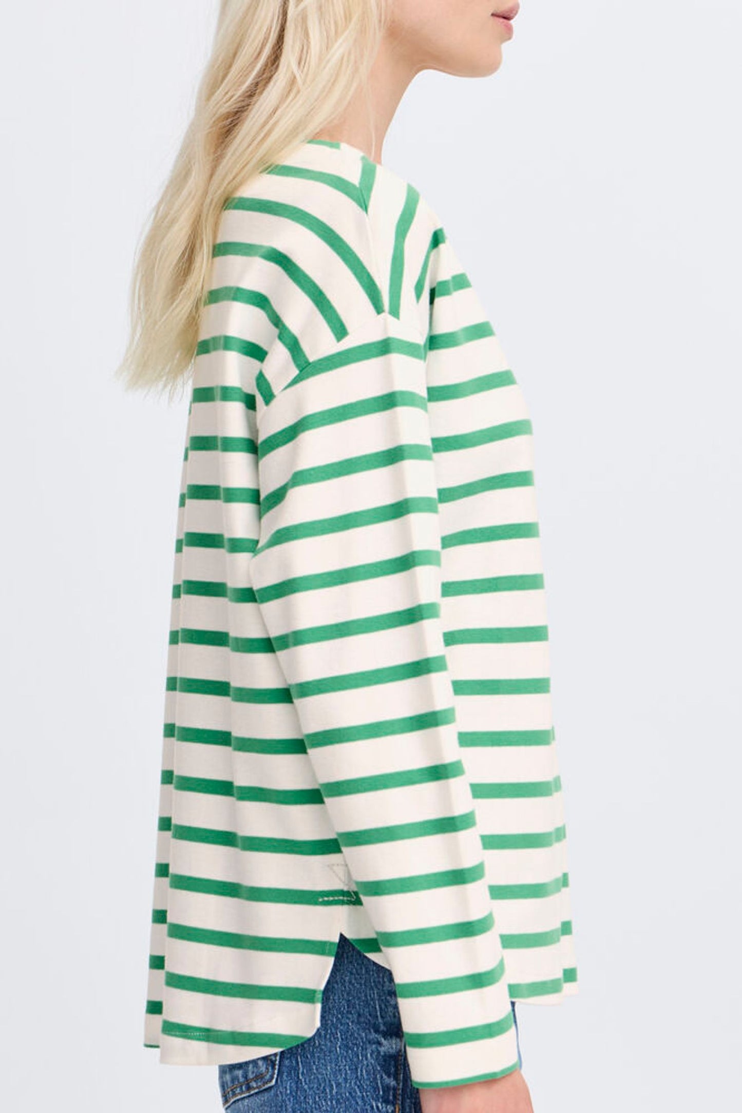 Person wearing a green and white striped sweater on a plain background