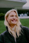 Woman with blonde hair smiling outdoors