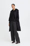 Woman wearing a black quilted coat on a white background