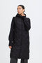 Woman wearing a black quilted coat on a white background