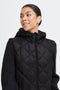 Woman wearing a black quilted jacket on a white background