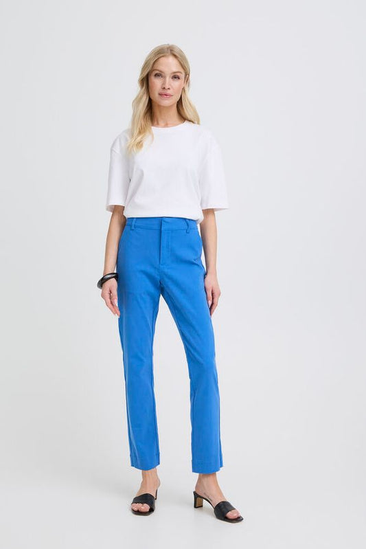 Woman wearing a white top and blue pants on a white background