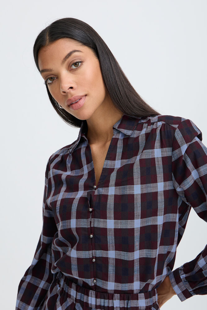 Woman wearing a plaid shirt against a white background