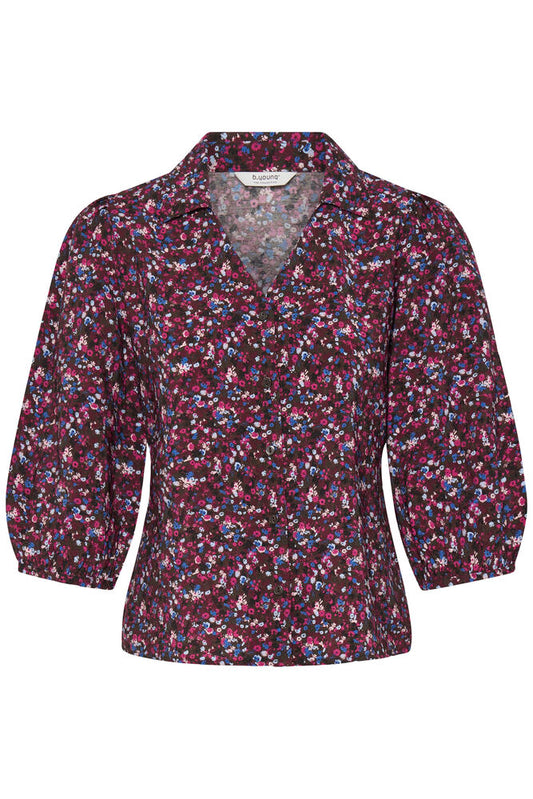 A women's long-sleeve blouse with a small-scale floral and abstract print in dark purple, pink, and blue on a black background, featuring a V-neckline and gathered sleeves.