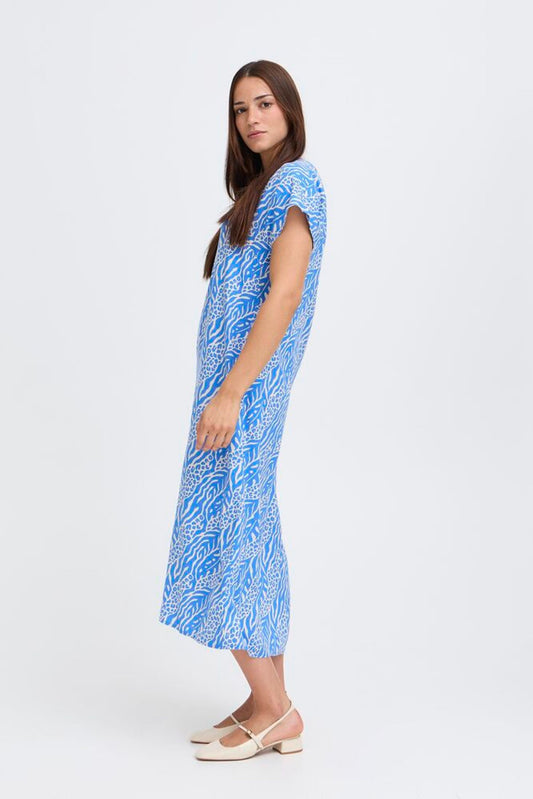 Woman wearing a blue patterned dress on a white background