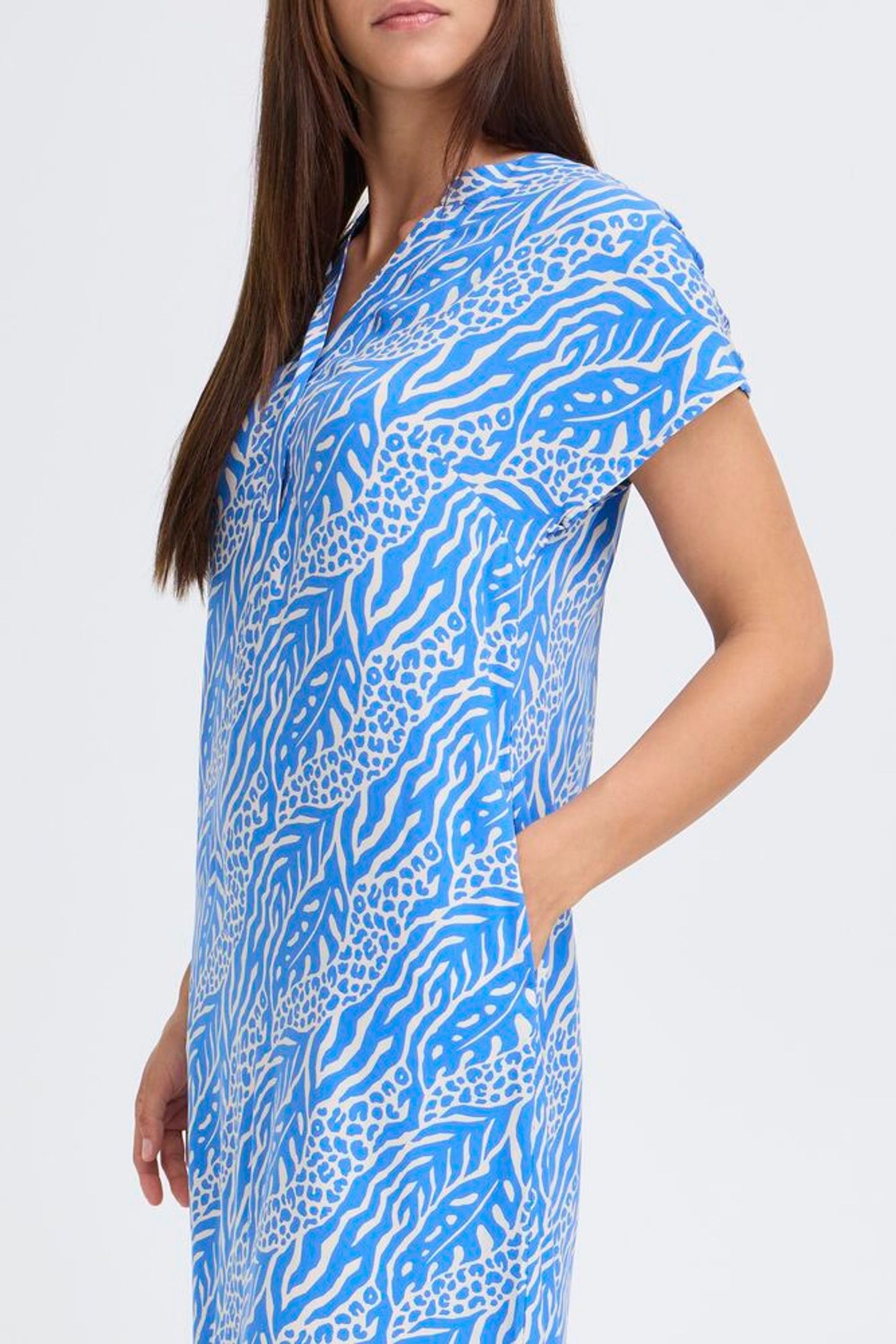 Woman wearing a blue patterned dress on a white background