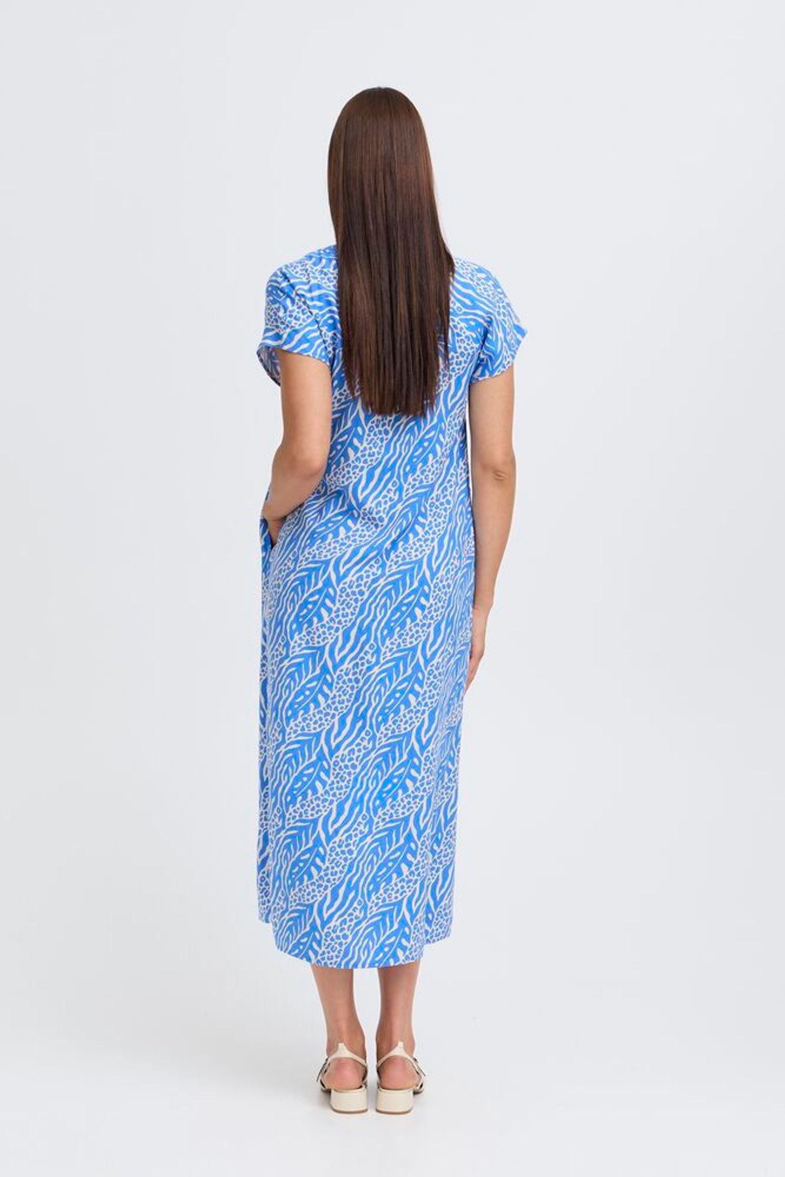 Woman wearing a blue patterned dress on a white background