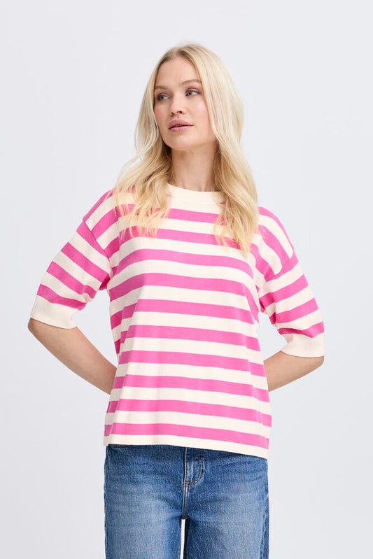 Woman wearing a pink and white striped shirt with blue jeans on a light gray background