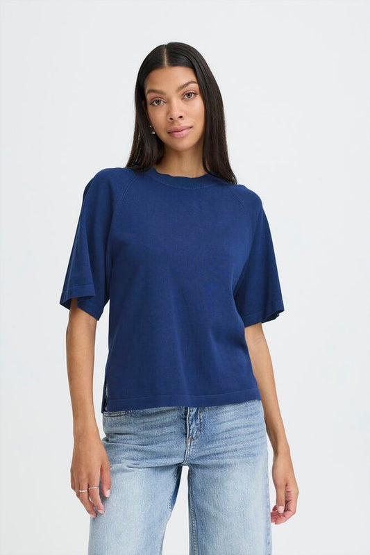 Woman wearing a blue oversized t-shirt and light blue jeans on a white background