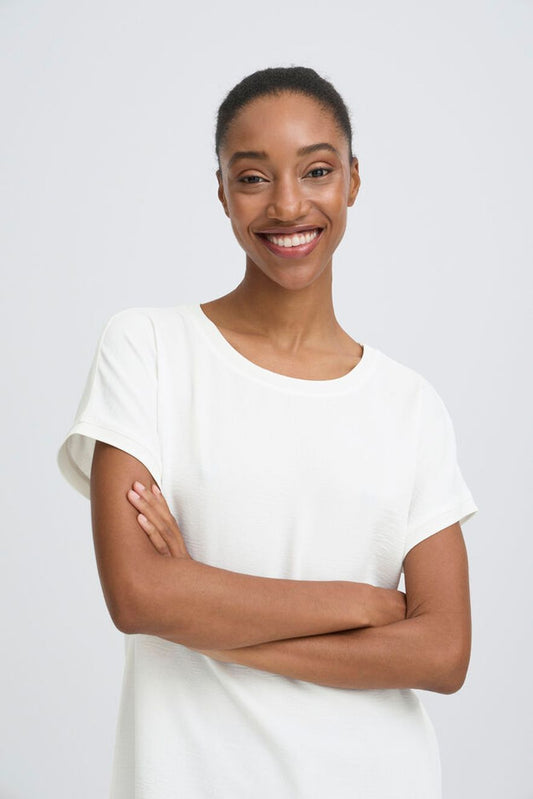Woman wearing a white dress against a plain background
