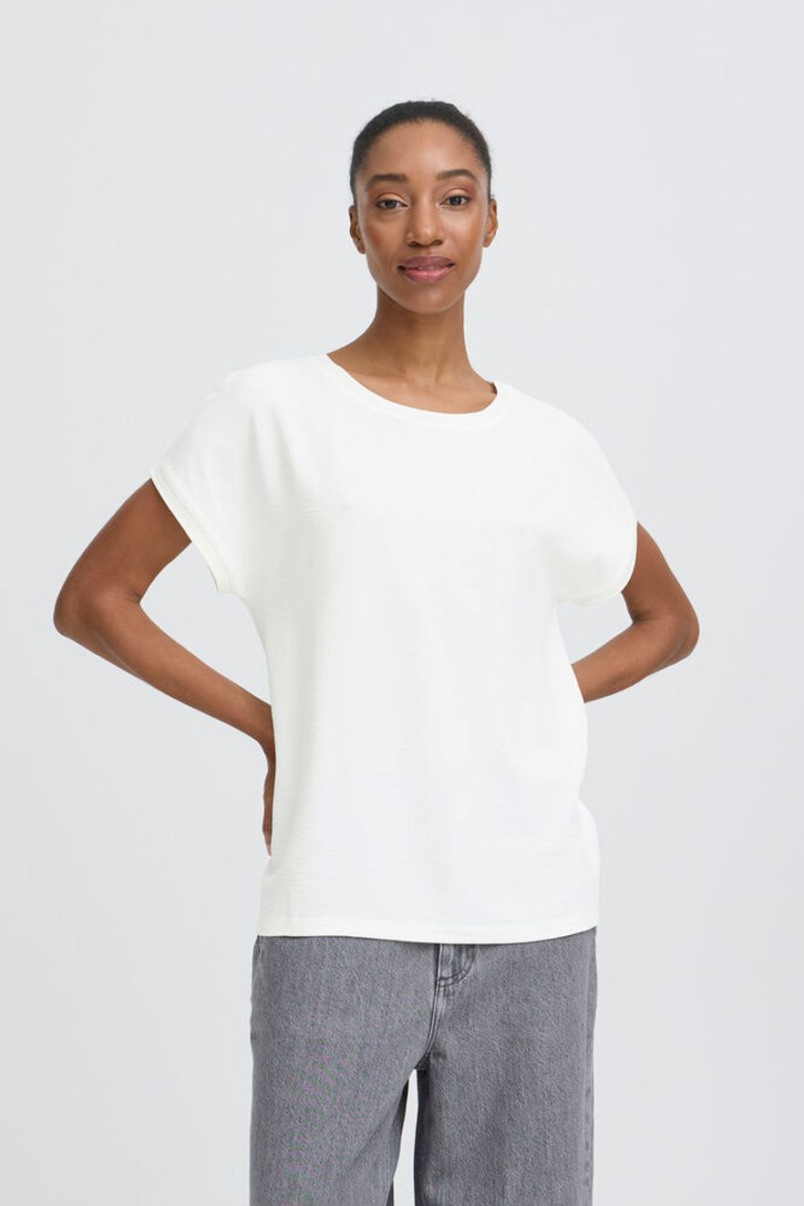 Woman wearing a white top and gray pants on a white background