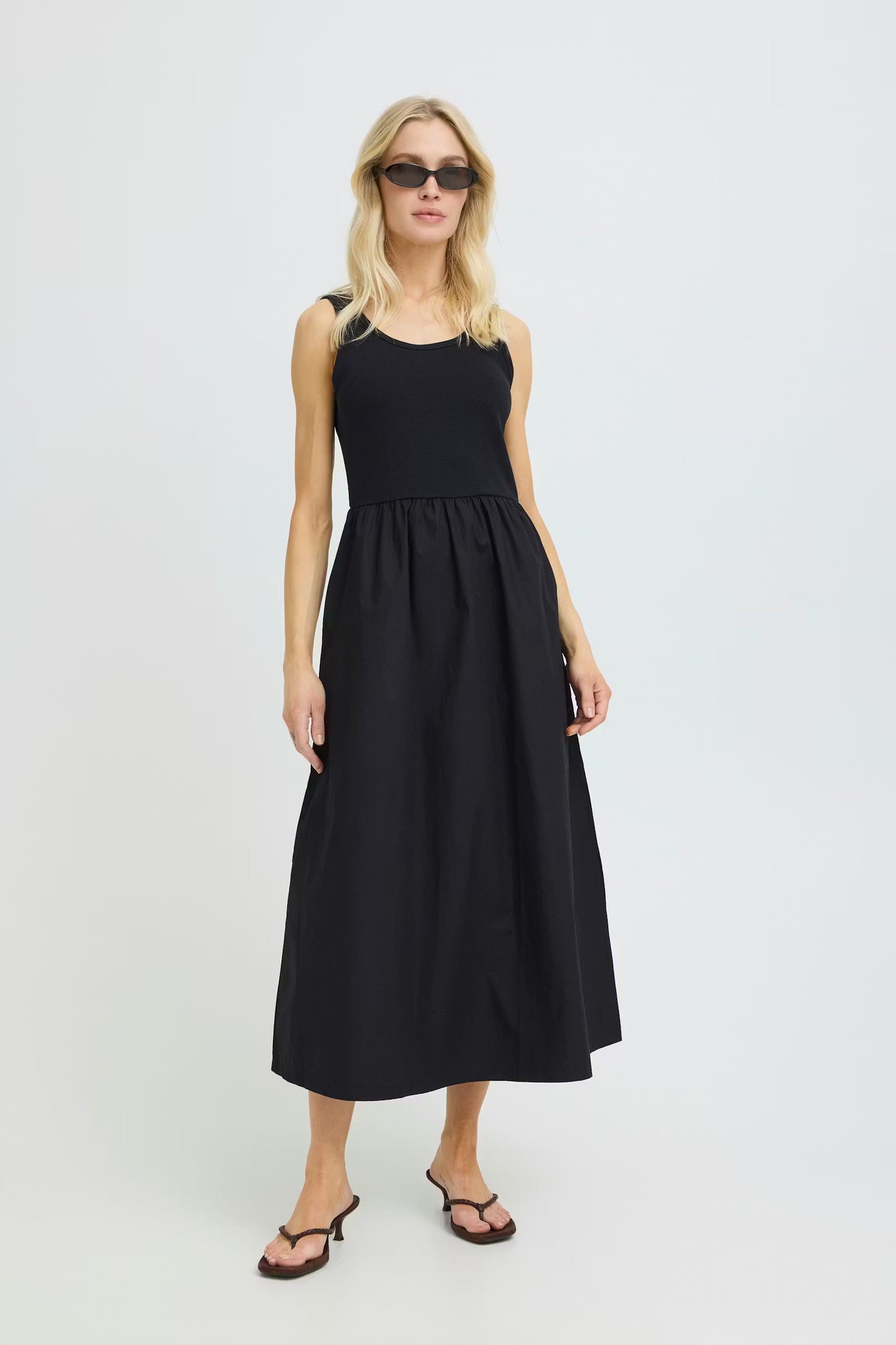 Woman wearing a black sleeveless dress on a white background