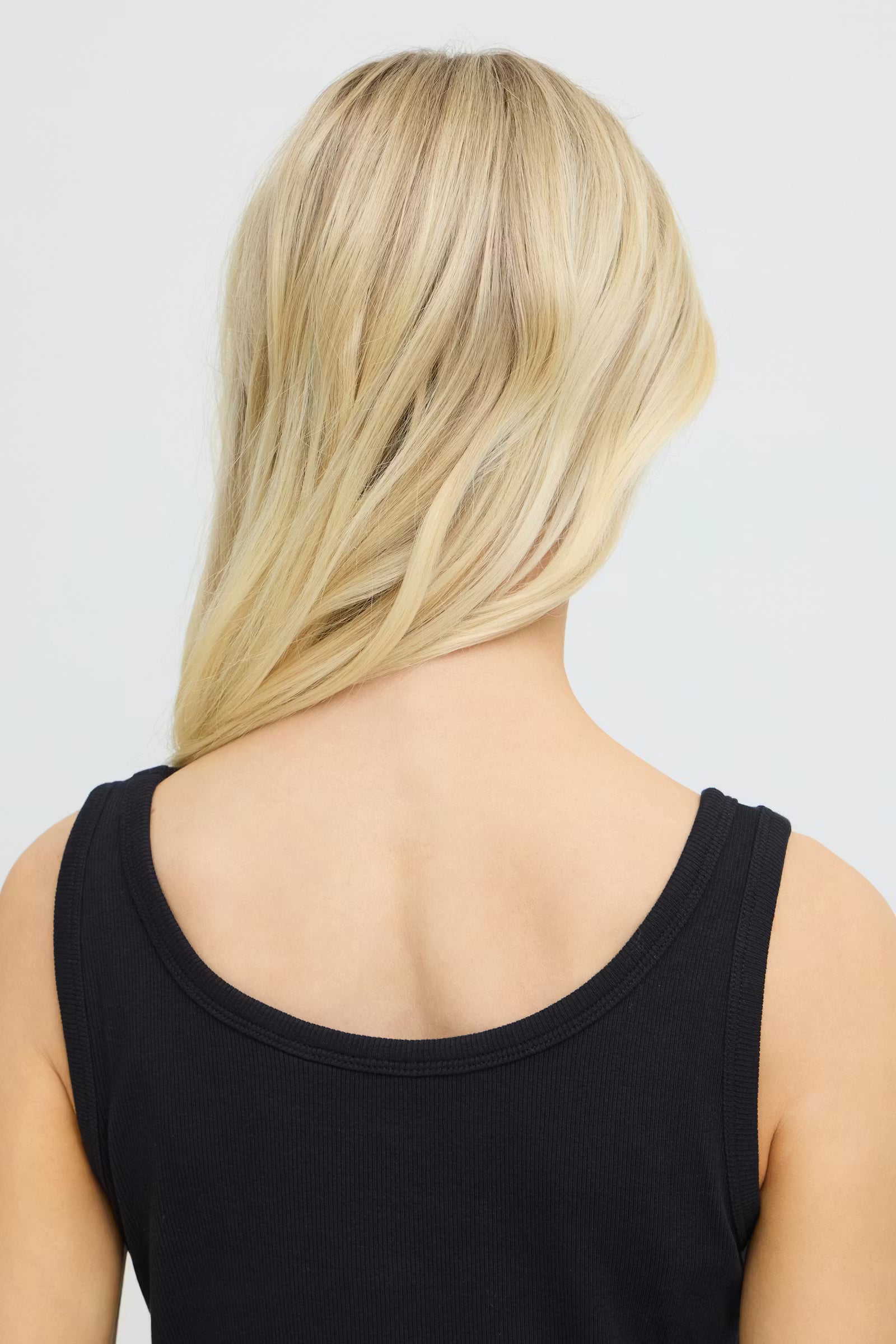 Person wearing a black dress with a plain background