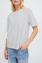 Person wearing a light gray t-shirt and blue jeans on a white background