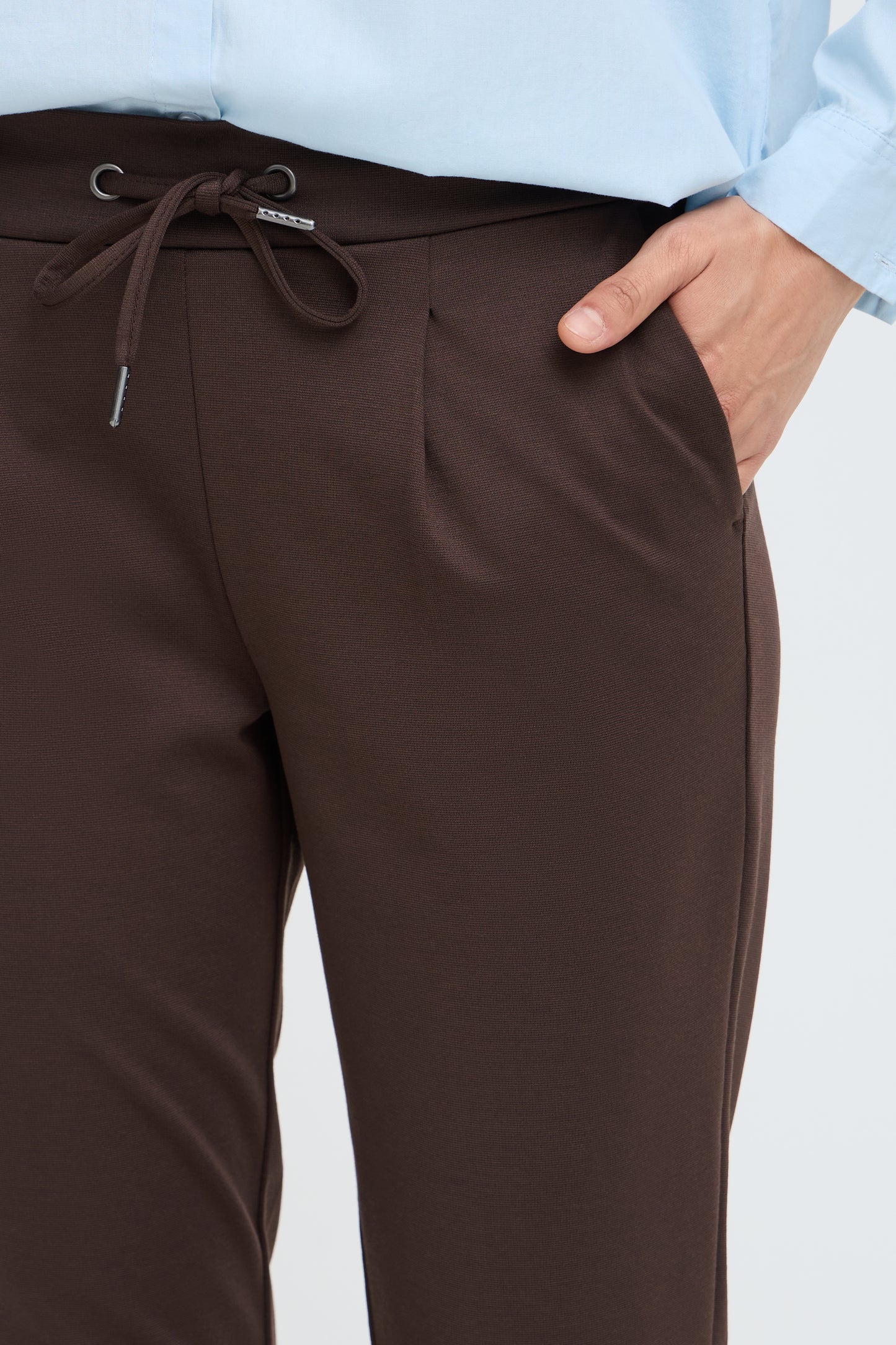Close up of drawstring tie on chocolate brown trousers