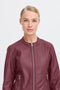 Woman wearing a burgundy leather jacket on a white background
