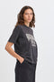Person wearing a black t-shirt with a graphic design on a white background