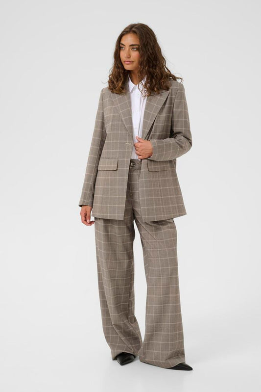 Woman wearing a brown checkered suit on a white background