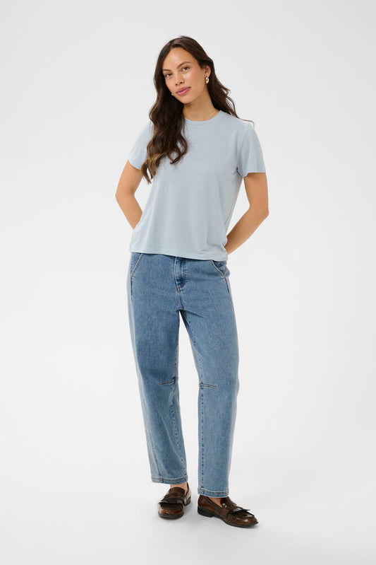 Woman wearing a light blue t-shirt and blue jeans on a white background