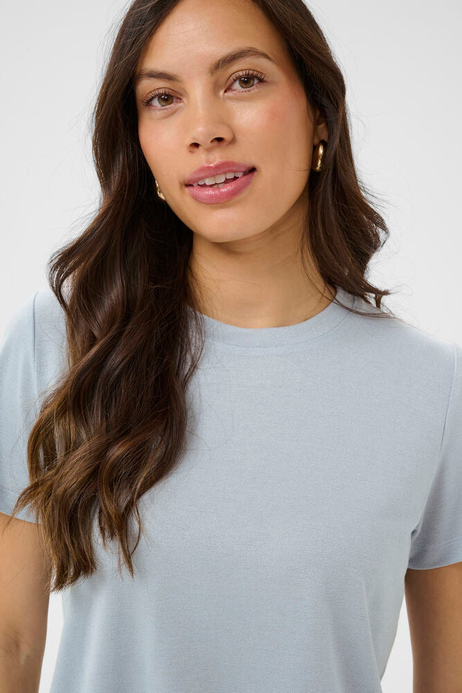 Woman wearing a light blue t-shirt against a white background