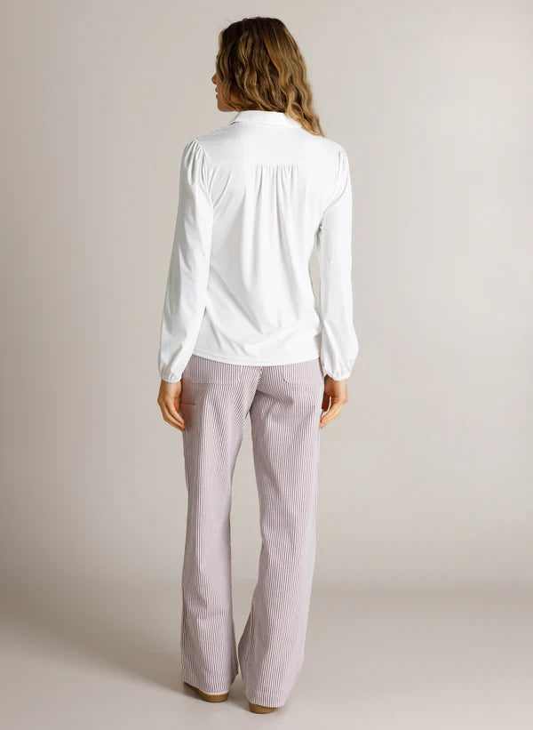 Back view of model in a long sleeve white shirt