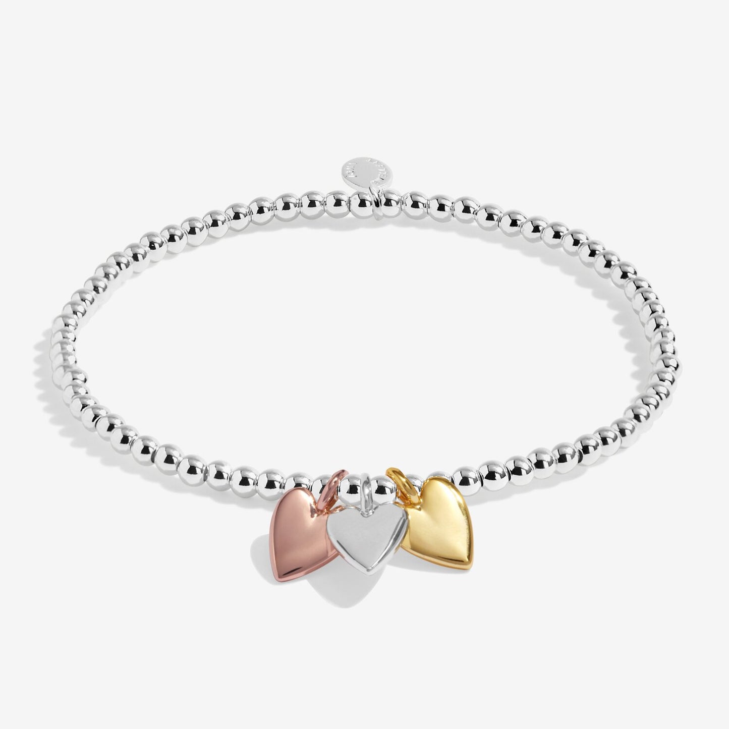 Silver bracelet with three heart-shaped charms in gold, silver, and rose gold on a white background.