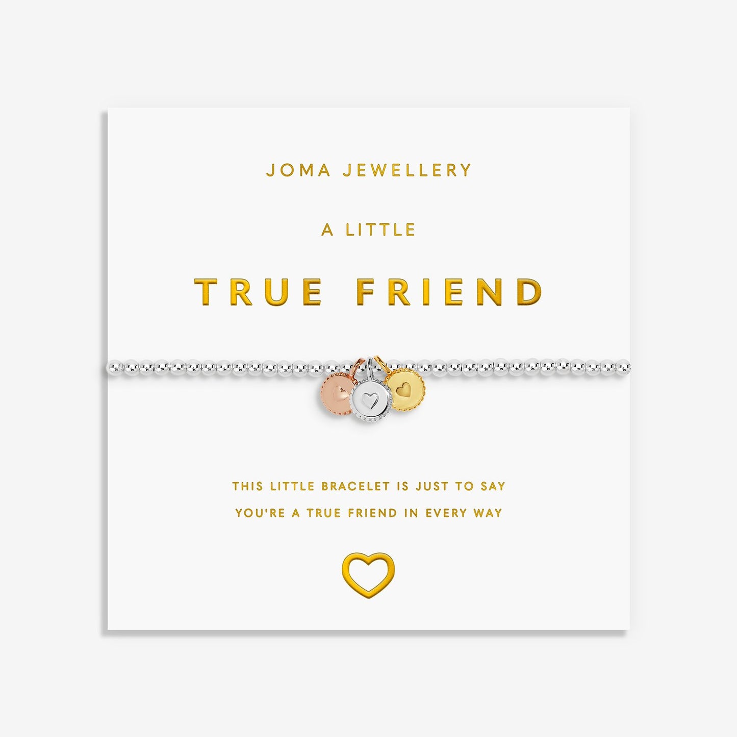 A silver friendship bracelet with three small charms (rose gold, silver, and gold) displayed on its white Joma Jewellery gift card, which features gold lettering and a gold heart outline.