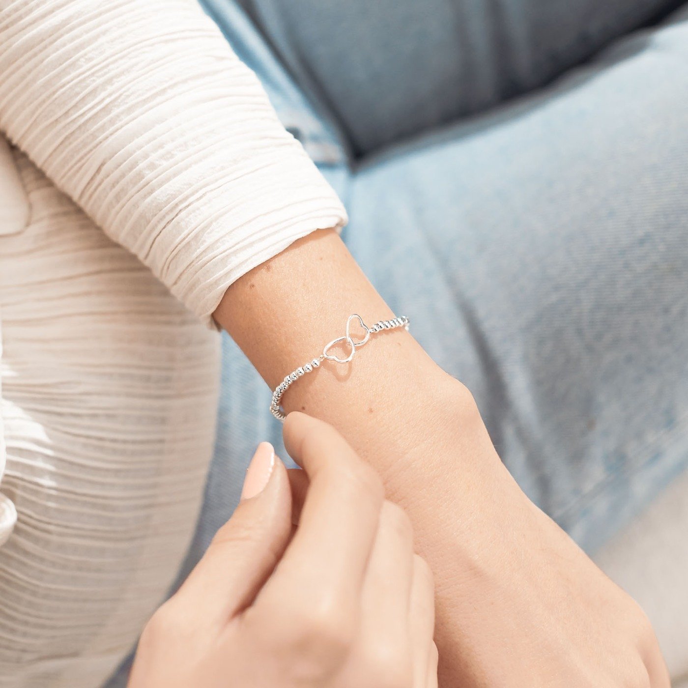 Silver bracelet on a wrist with a blurred background
