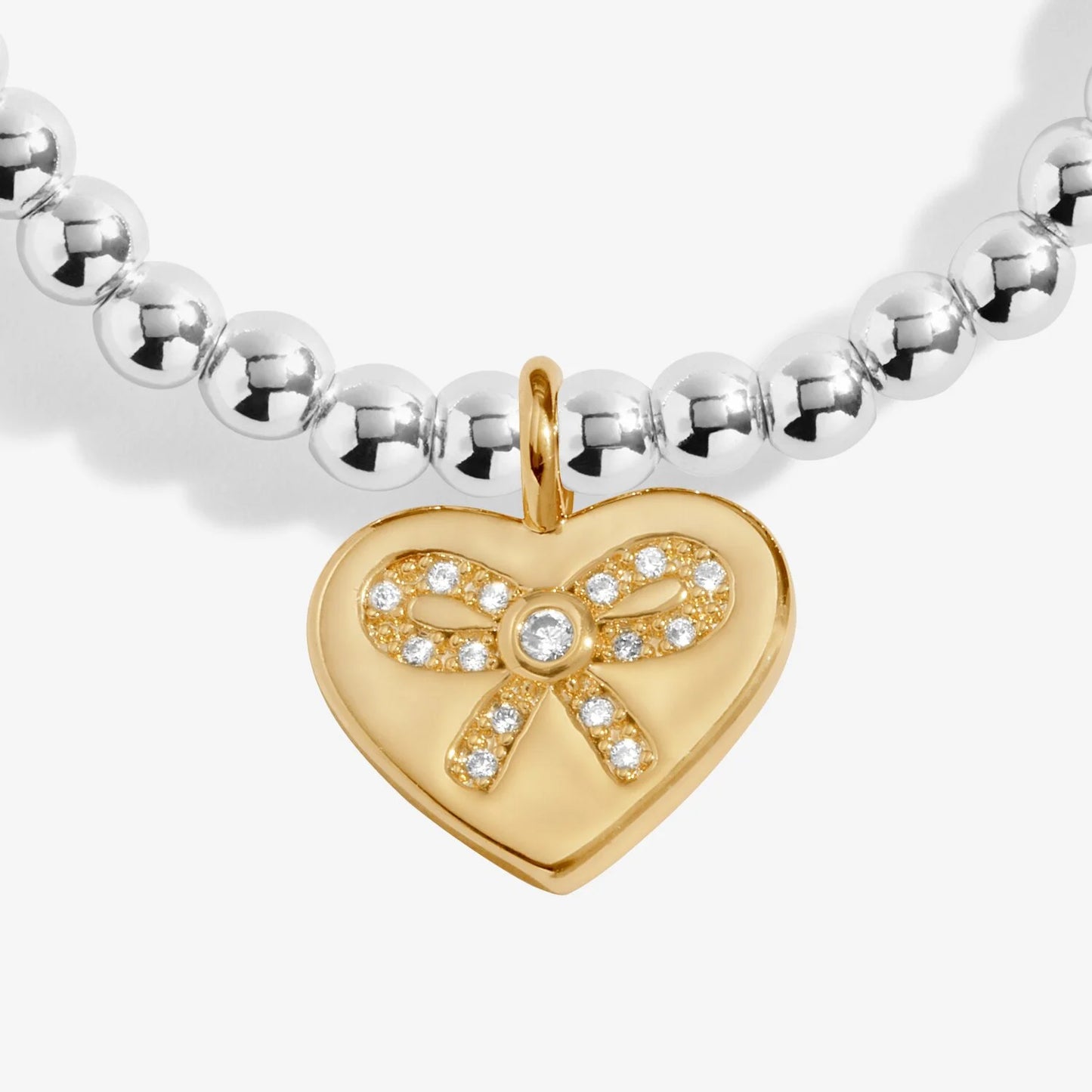 Gold heart-shaped pendant with bow design on a silver beaded bracelet