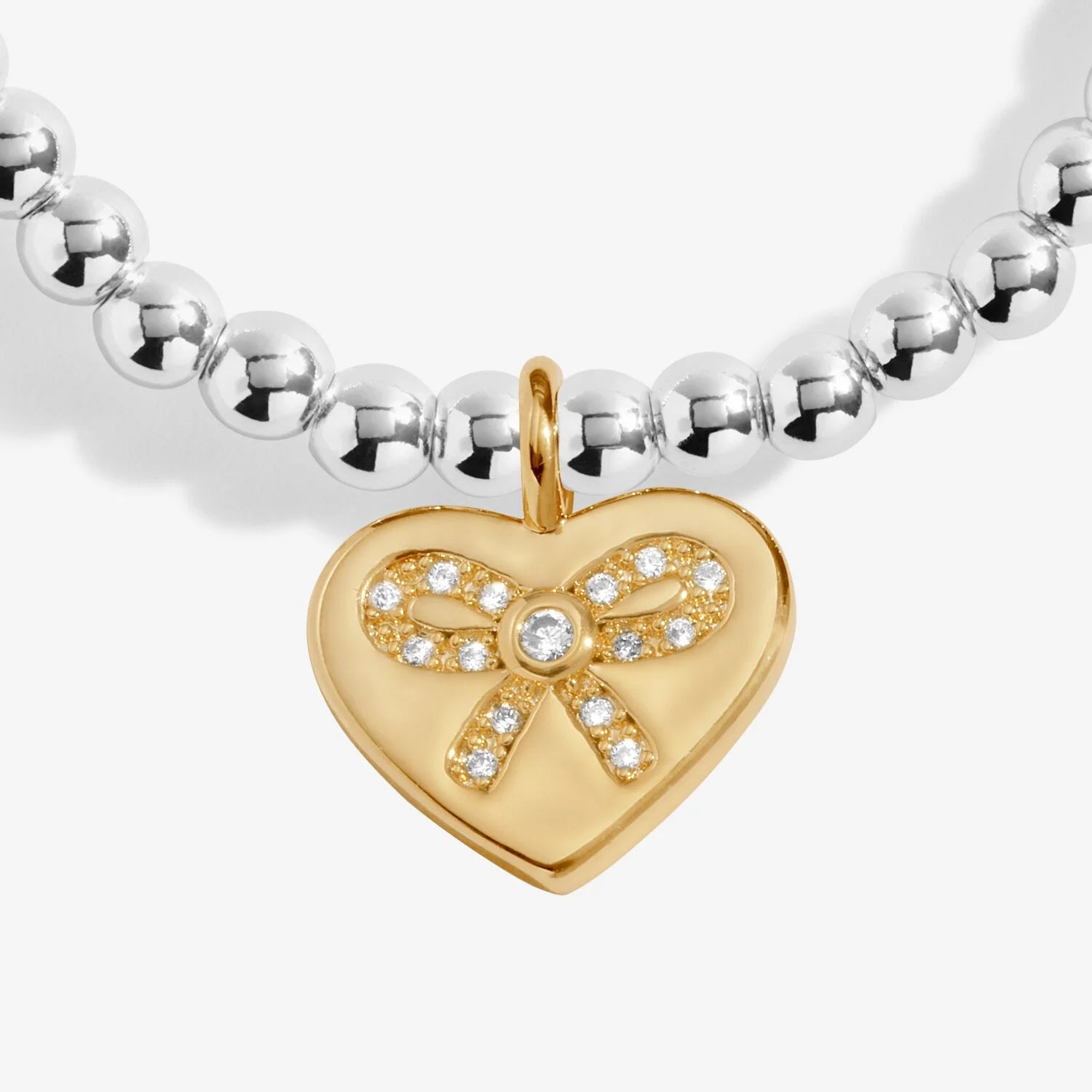 Gold heart-shaped pendant with bow design on a silver beaded bracelet