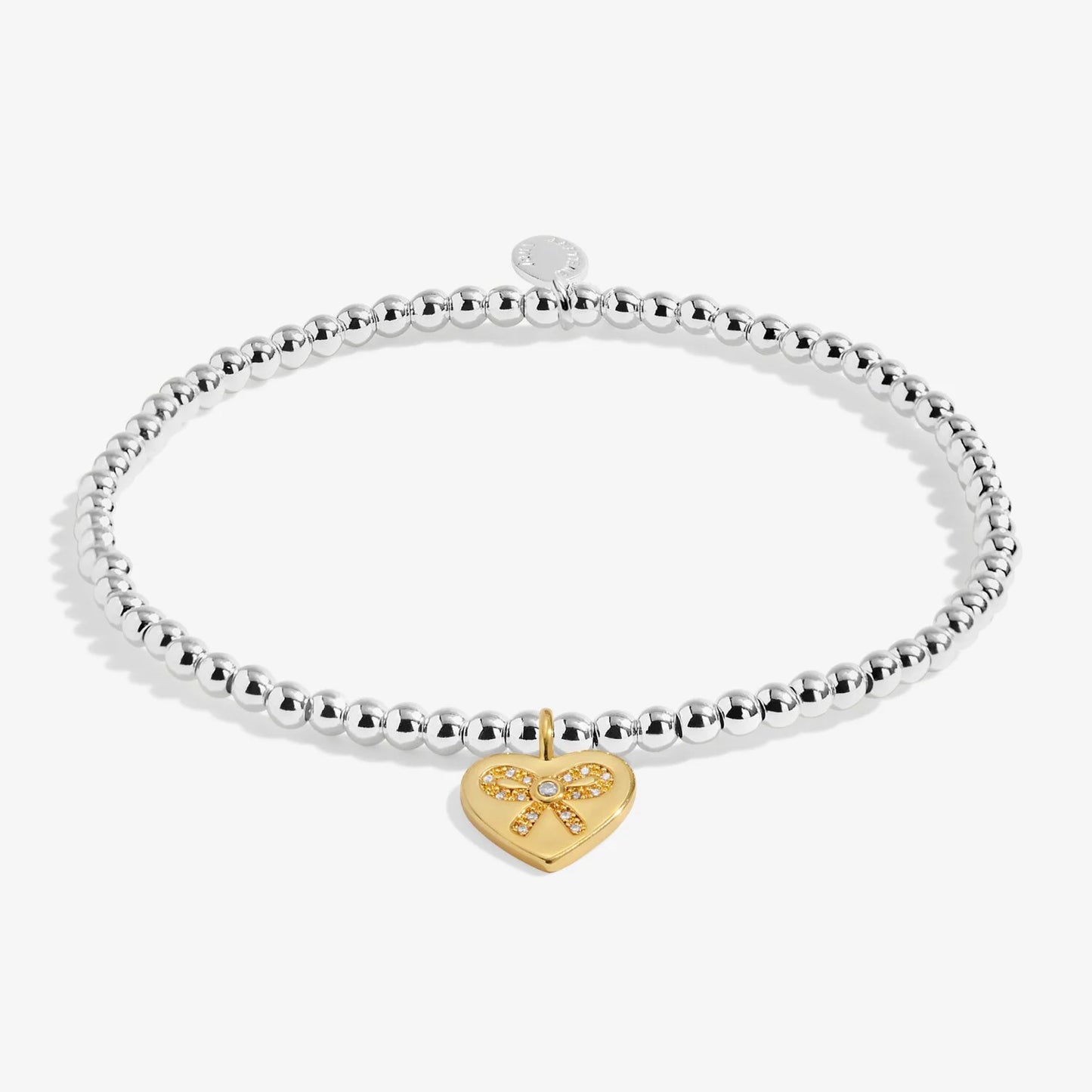 Silver bracelet with a gold heart-shaped charm on a white background