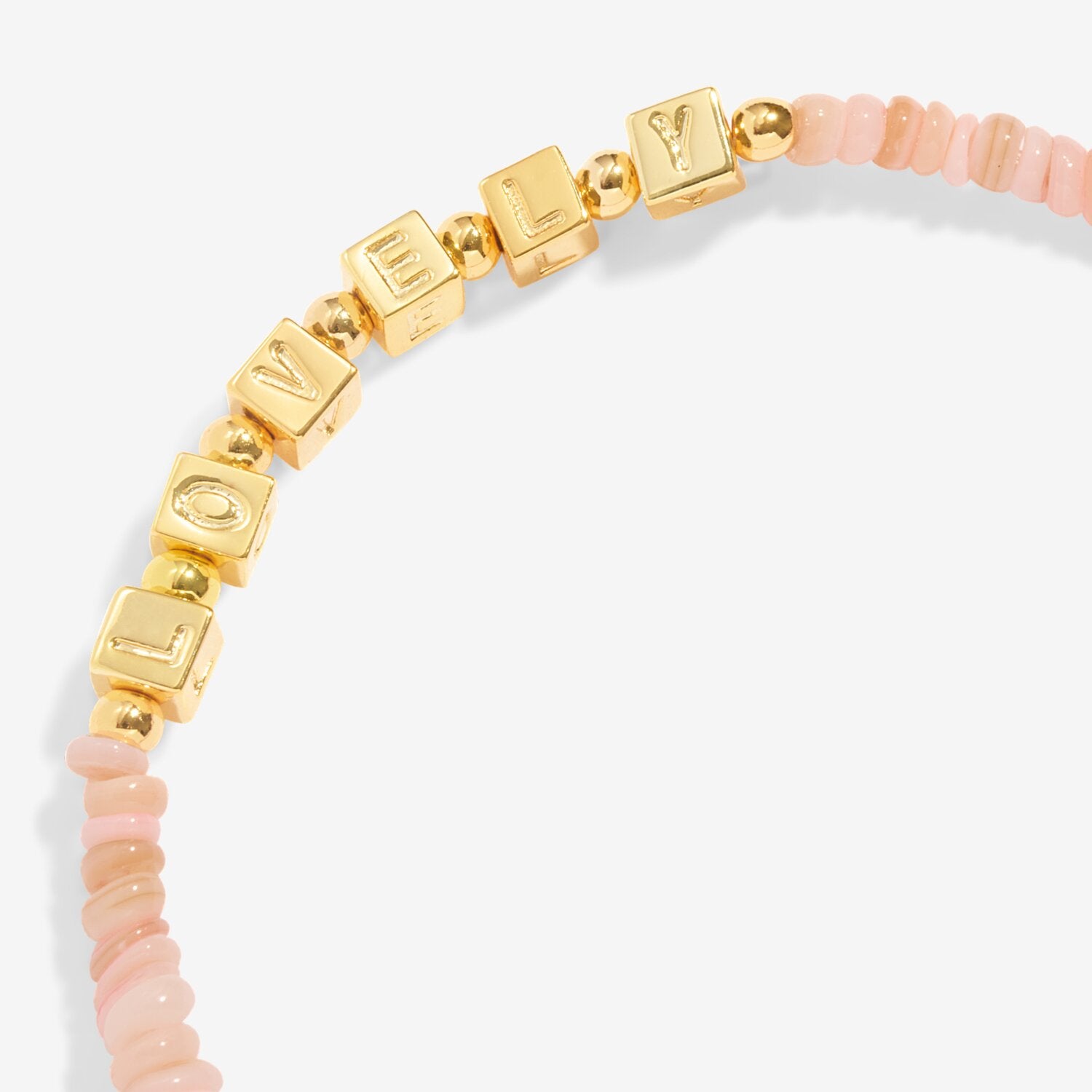 Bracelet with gold letter beads and pink beaded accents on a white background