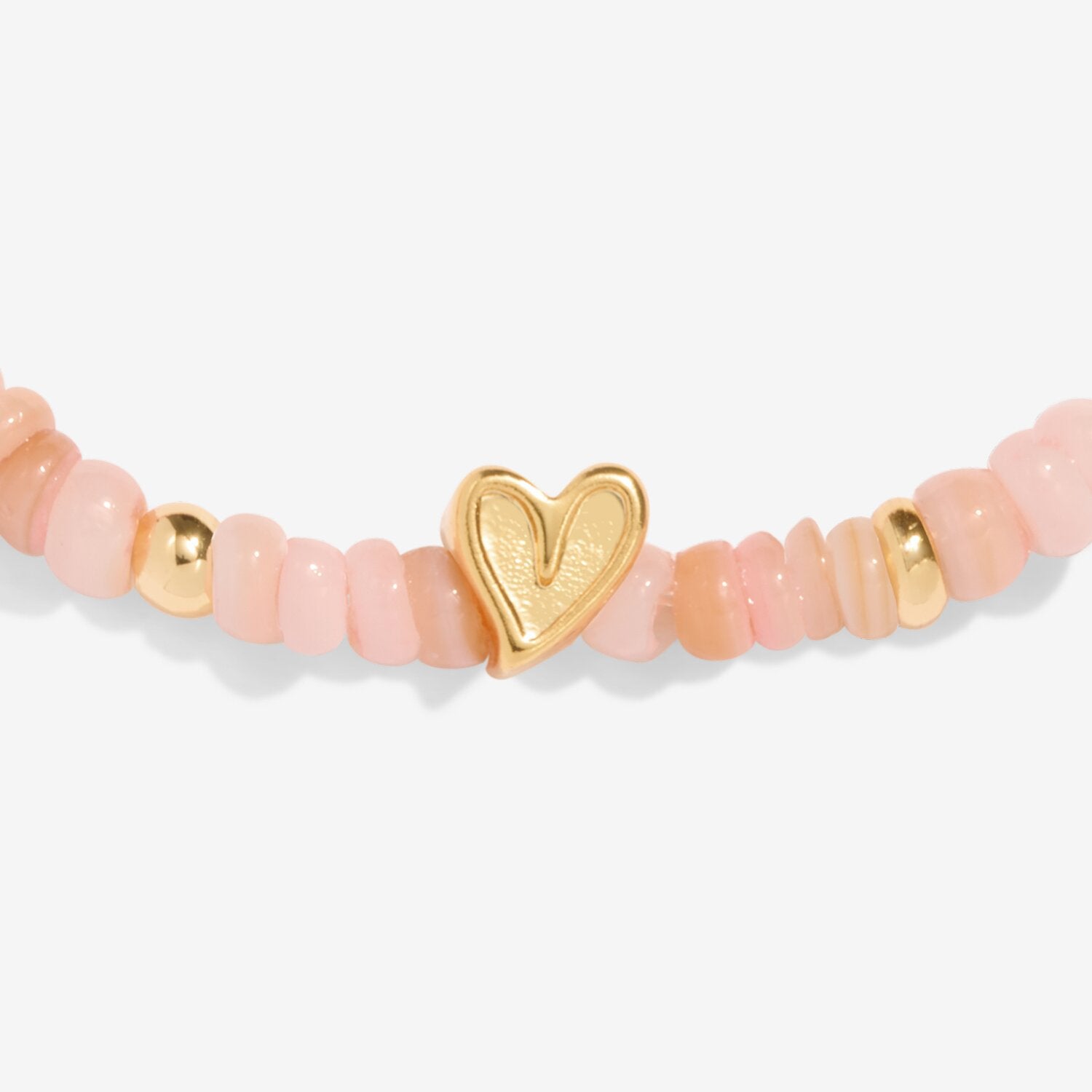 Bracelet with pink beads and a gold heart charm on a white background