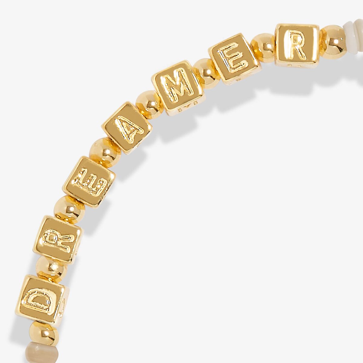 Gold letter beads spelling 'DREAMER' on a white background